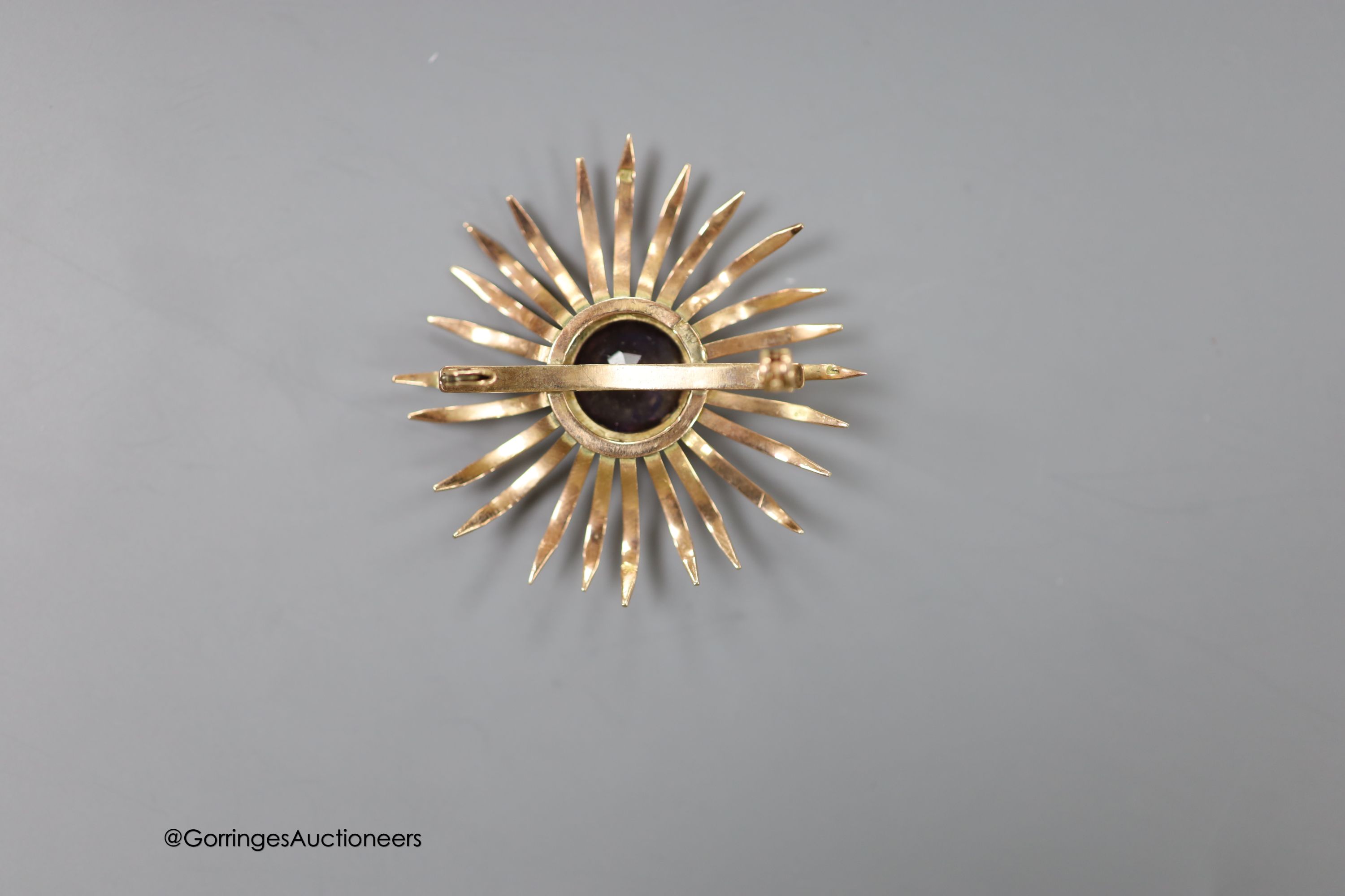 A Middle Eastern yellow metal and synthetic colour change corundum set brooch, 41mm, gross weight 6.9 grams (pin missing).